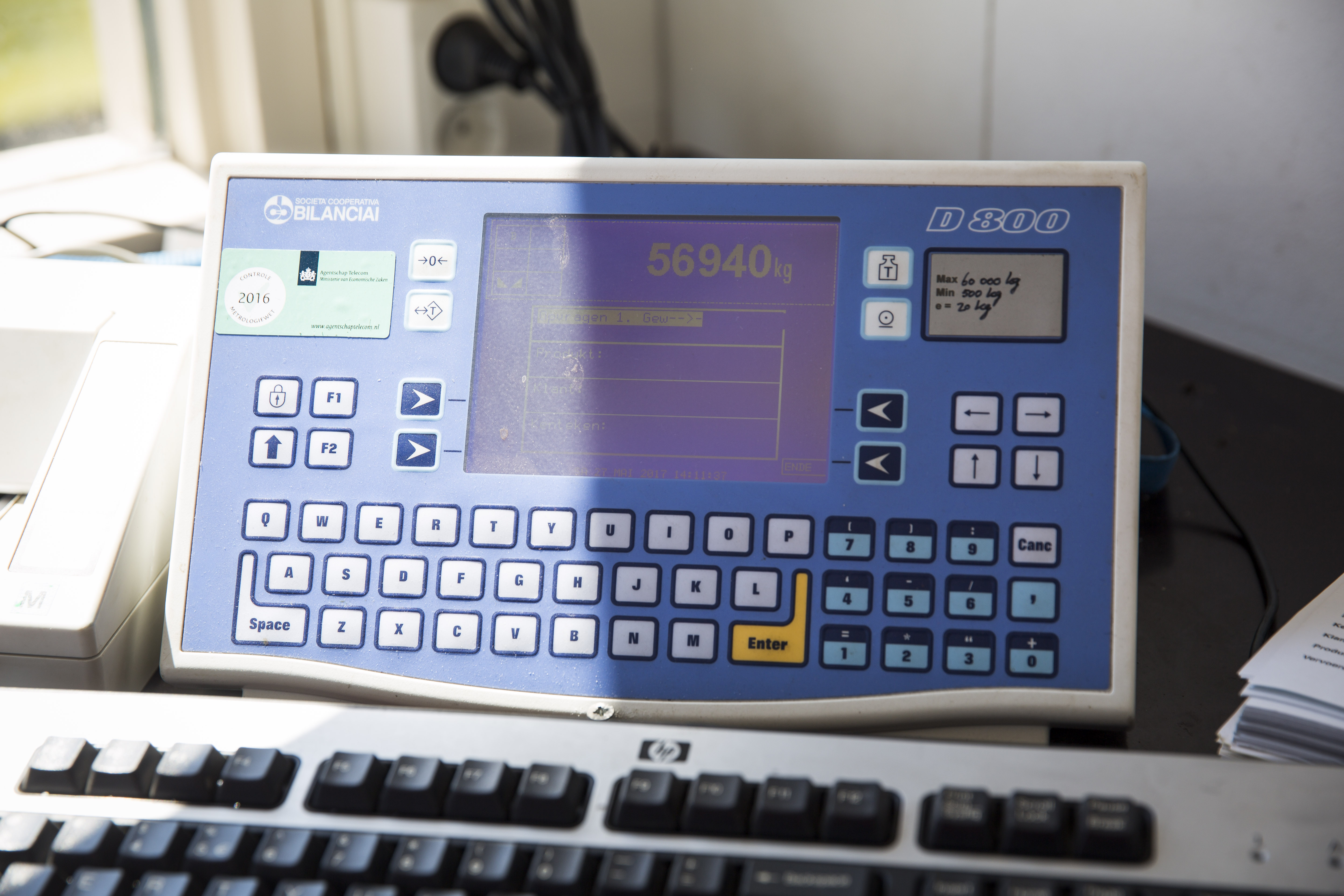 Op het scherm van de weegcomputer is direct het totaalgewicht af te lezen. Dit wordt samen met bijvoorbeeld het kenteken, datum, tijd en geladen materiaal geregistreerd. Linksboven op het scherm staat de sticker die bewijst dat het systeem is goedgekeurd door de overheid. 