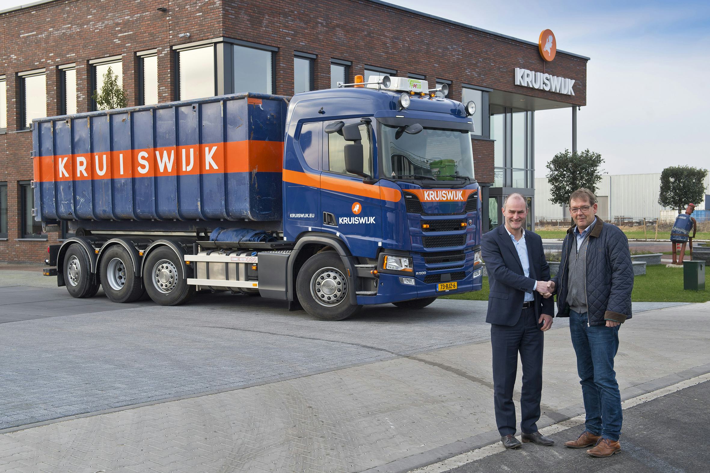 Dirk Slingerland (R) van Kruiswijk grondwerken in Bergambacht neemt de sleutels van de nieuwe Scania R500 8x2/*6 in ontvangst uit handen van Gertjan Schuurman van Waddinxveen.