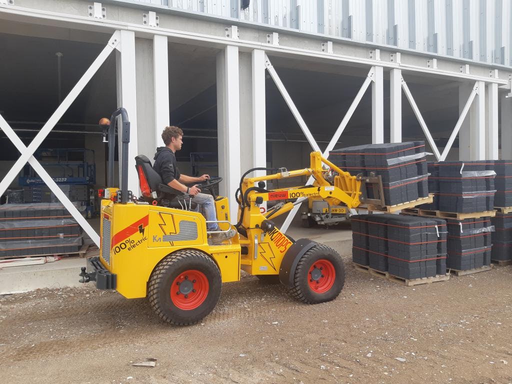 De Knikmops 180E pakt een pallet met stenen op bij een parkeergarage in Amsterdam.