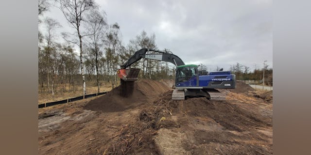 Het afgraven en zeven van munitie verdachte grond met een beveiligde machine. Twan Derksen wint met deze foto een gratis jaarabonnement op BouwMachines.