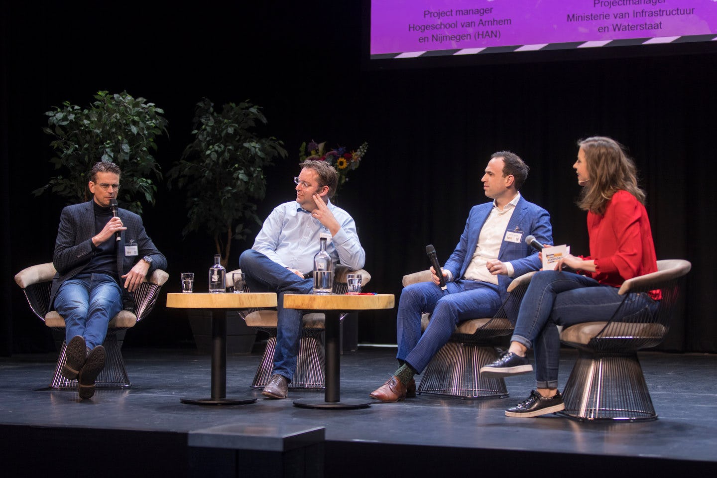 Harry Hertsenberg, voorzitter KOMAT en directeur Infra Van Werven, Chris Huijboom, HAN Automotive Research, Valentijn Holewijn, Projectmanager Schoon en Emissieloos Bouwen bij Ministerie van Infrastructuur en Waterstaat (v.l.n.r.) in gesprek met dagvoorzitter Sandy Nijhuis.