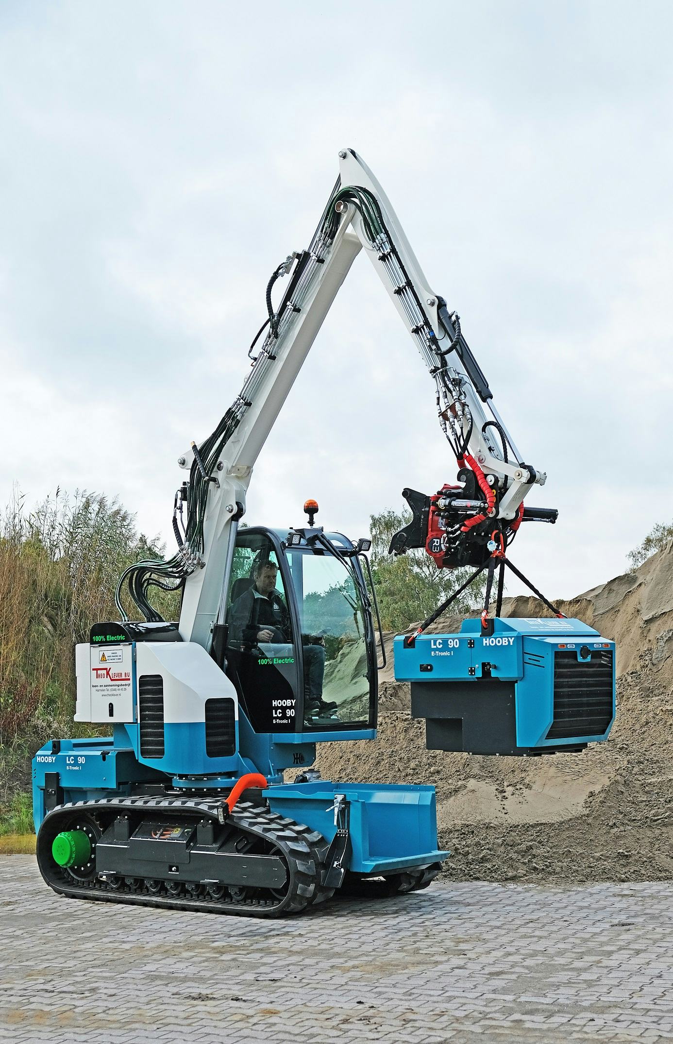 De machine tilt de accu zelf uit de houder om hem dan op de gewenste plek te zetten.