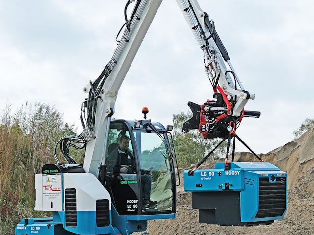 De machine tilt de accu zelf uit de houder om hem dan op de gewenste plek te zetten.