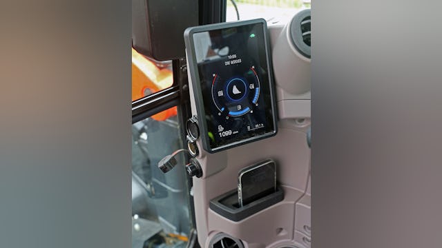 Links van het overzichtelijke 7” scherm een stekkerplug voor laadstroom, eronder een USB-aansluiting, handig om de smartphone op te laden die een eigen plekje heeft.