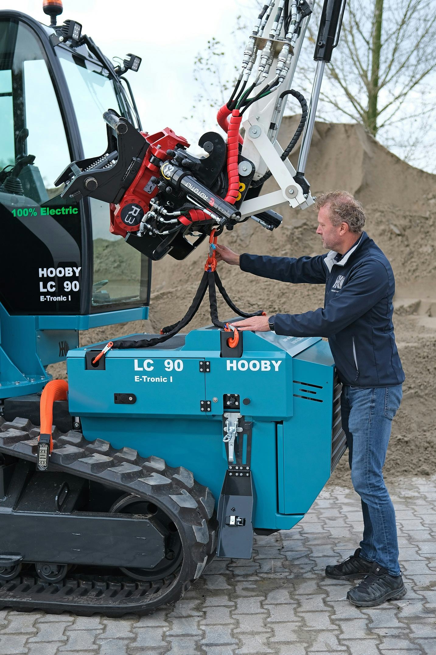 Het wisselen van accu begint met het ontkoppelen van de stroomverbinding, dan ontgrendelen en de  draaglussen inhaken. 