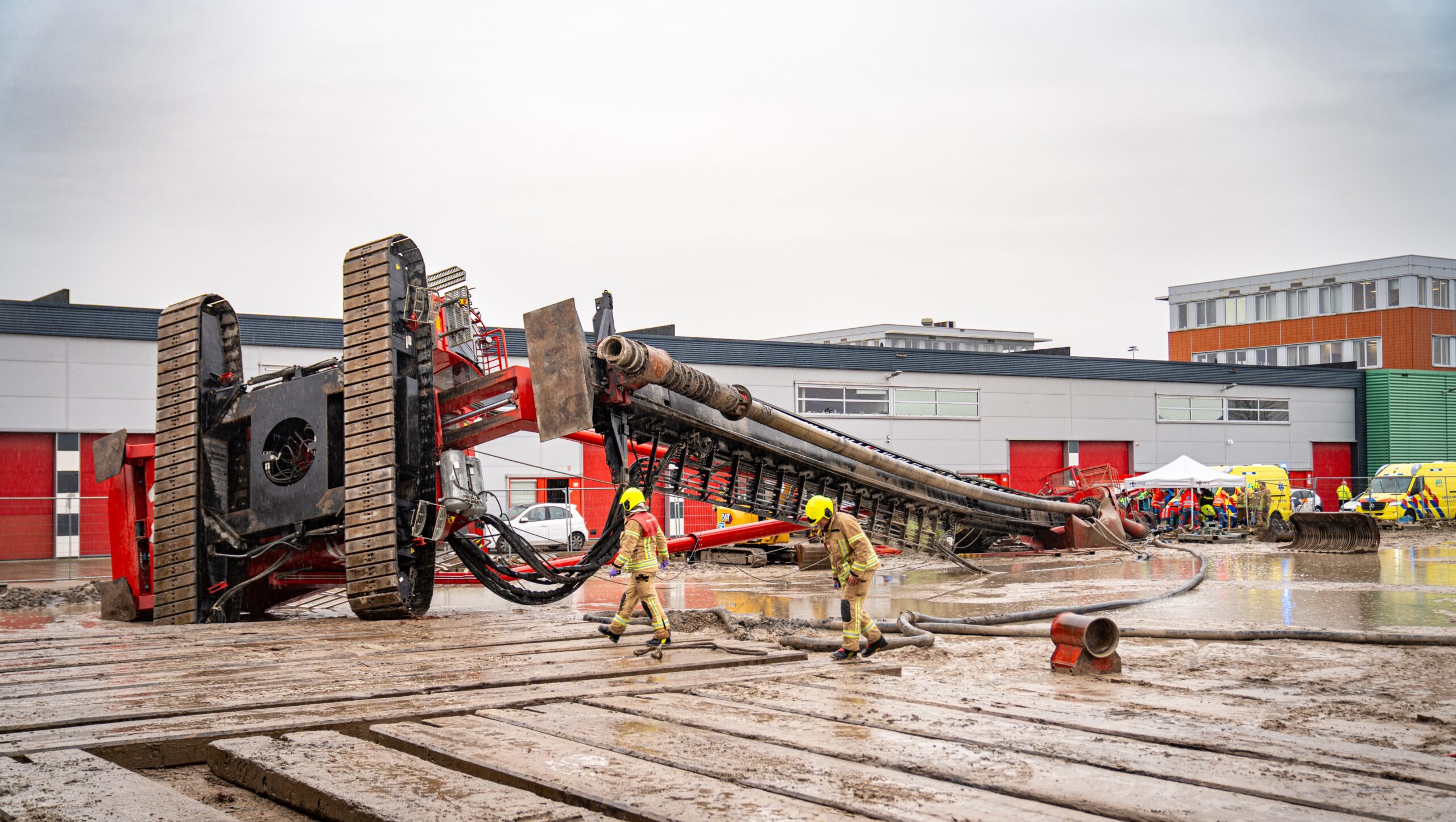 Brandweermannen inspecteren de omgevallen heistelling op het industrieterrein Waalhaven. (Foto: Kilian Lindenburg/MediaTV)