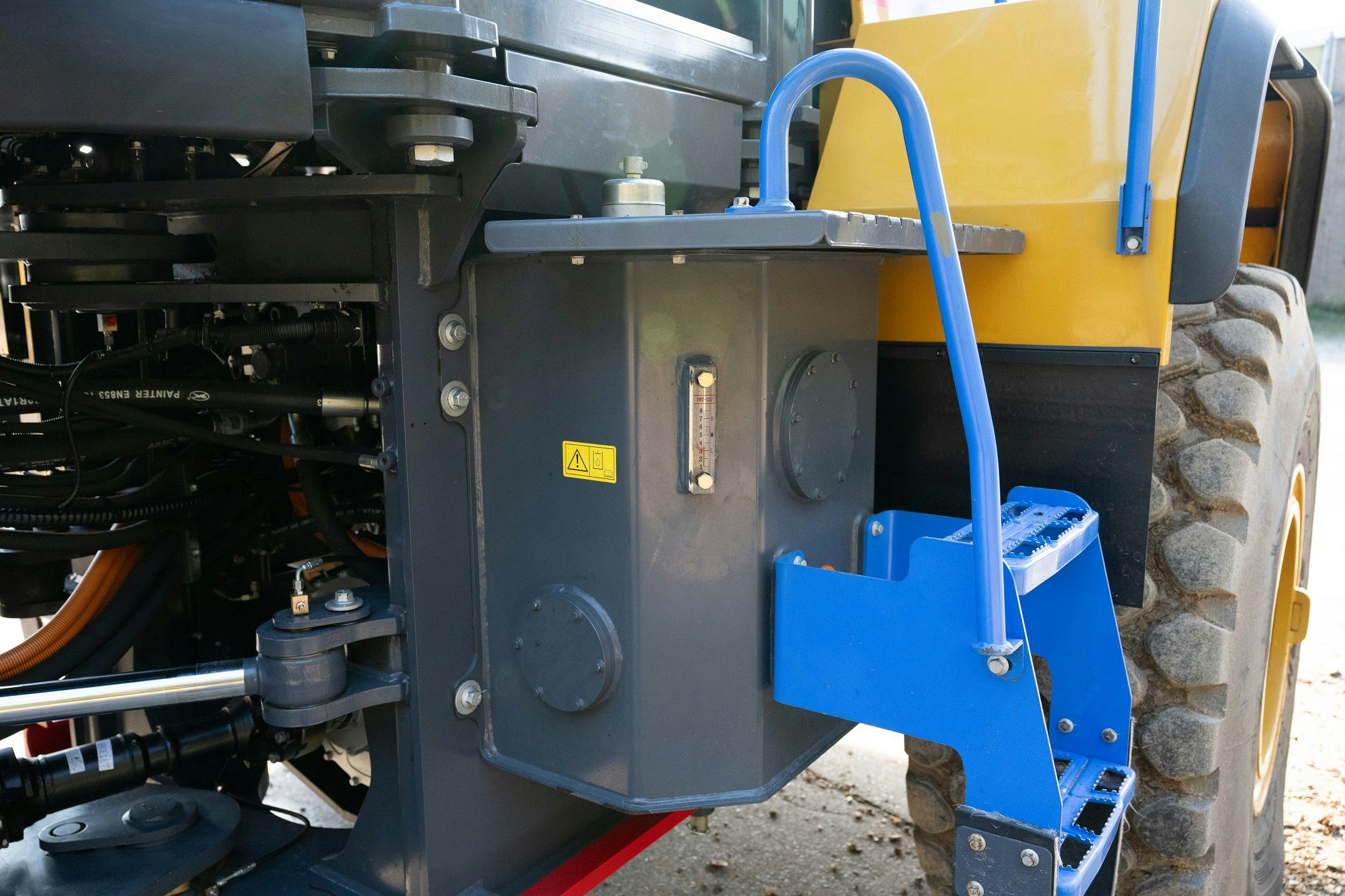 De trap naar de cabine gaat over de hydrauliektank heen.