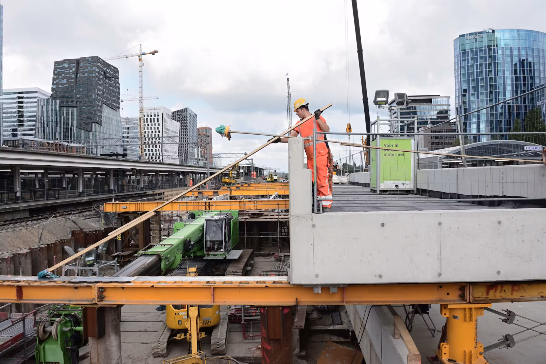 Een medewerkers van combinatie Nieuw-Zuid brengt smeermiddel aan op de baan, waarover het metrodek naar zijn plek glijdt. Foto: Ronald Bakker
